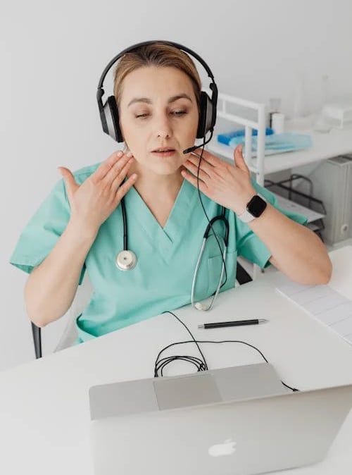 a woman in a green scrub suit and headphones