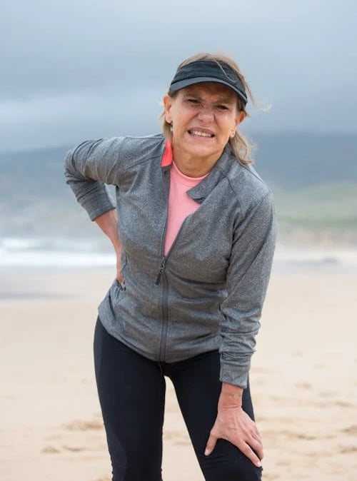 a woman in a gray jacket and pink top hat