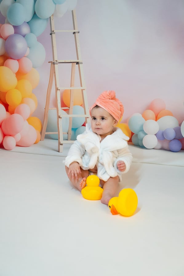 a baby in a white robe and a rubber ducky ducky