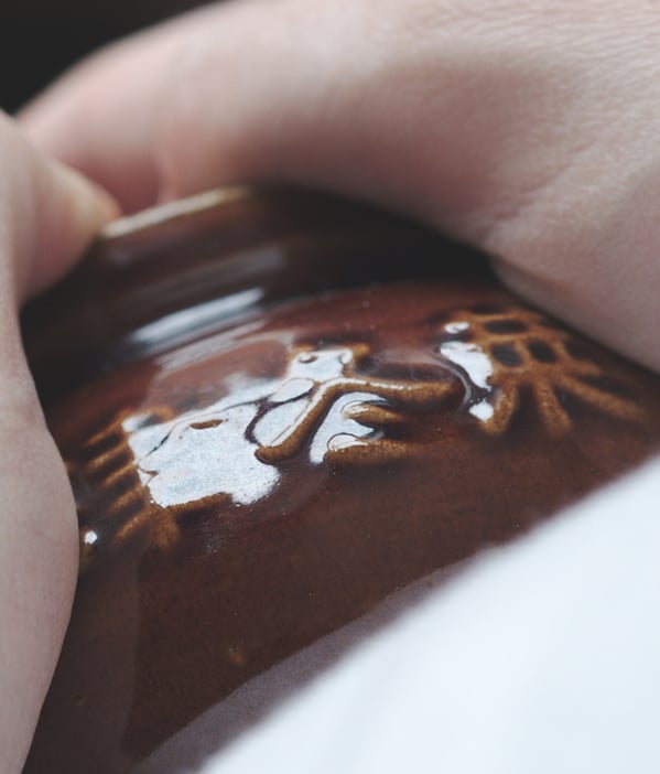 Clay pot with Chinese calligraphy held in hands