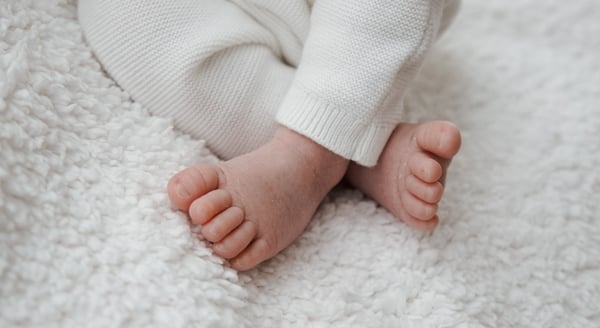 a baby's feet and toes on a white blanket