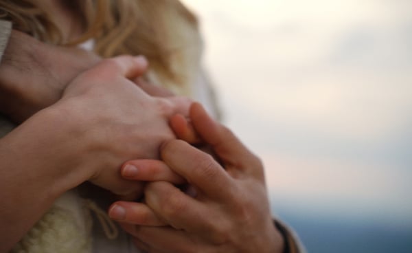 Photo des mains entrelacées d'un couple.