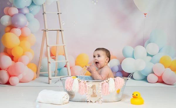 a baby in a tubtub with balloons and balloons