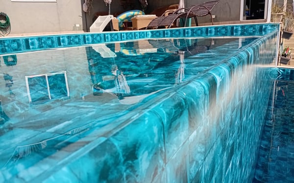 Piscina de vinil com água em tom esmeralda mostrando o efeito da estampa