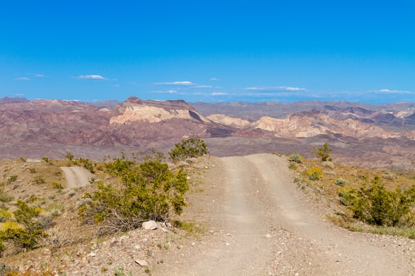 dirt road with mountains in the background