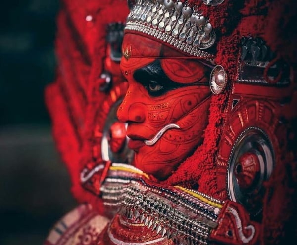 A side view of artist playing traditional Theyyam dance form