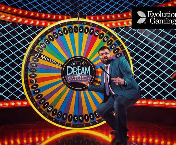a man in a suit and tie standing in front of a wheel of fortune