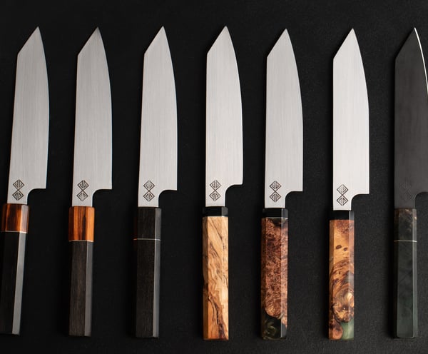 a set of five baltic blades chef knives and knives on a black background