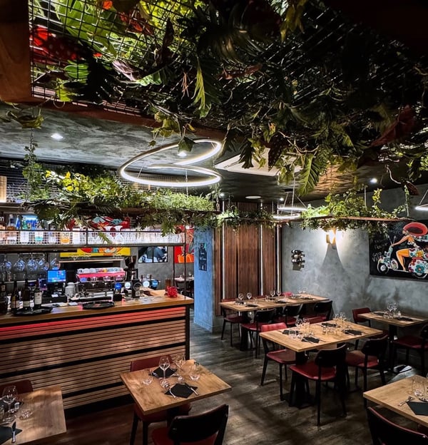 a restaurant with a large amount of plants and a bar
