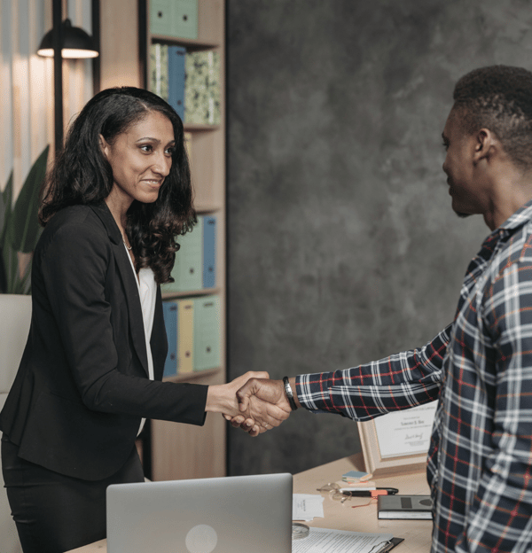 a man and woman shaking hands in a meeting room