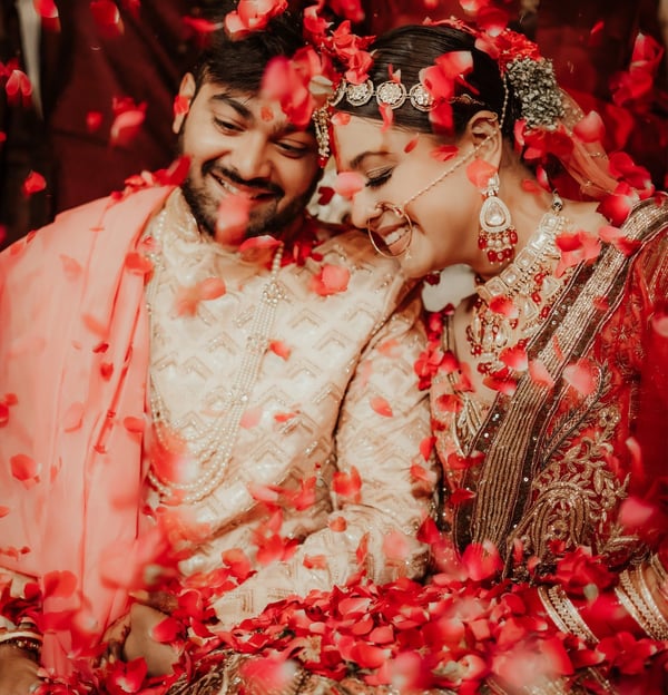 a bride and groom are standing in a flower filled room