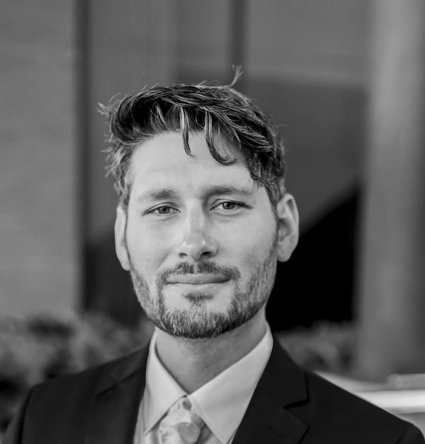 a man in a suit and tie standing in front of a building