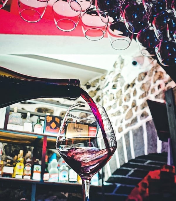 a wine glass being poured with wine