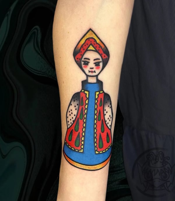 Tattoo of a russian doll but cartonish.