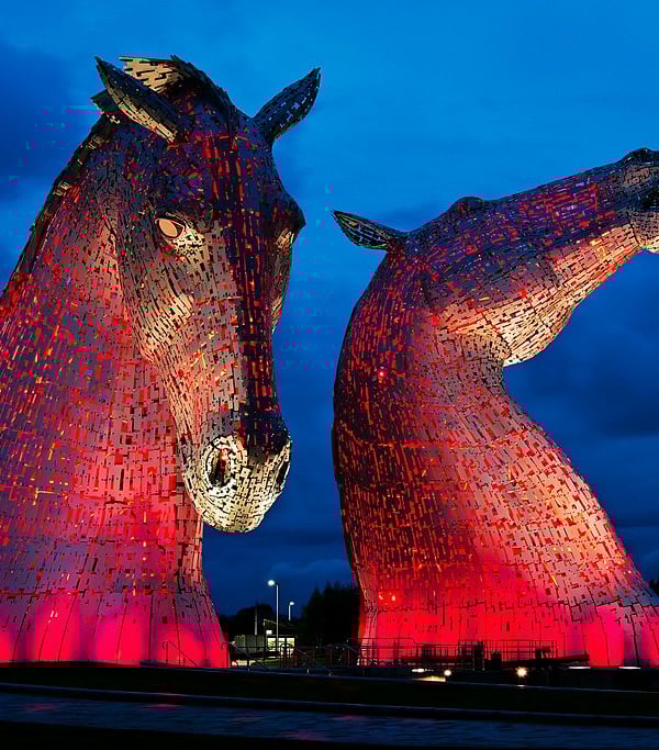 The Kelpies, lit sculpture against night sky.