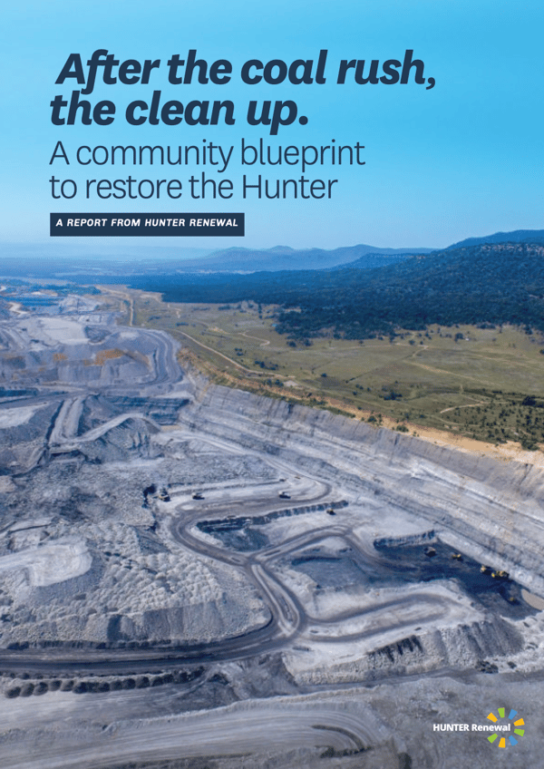 A large open cut coal mine with a blue sky and report title