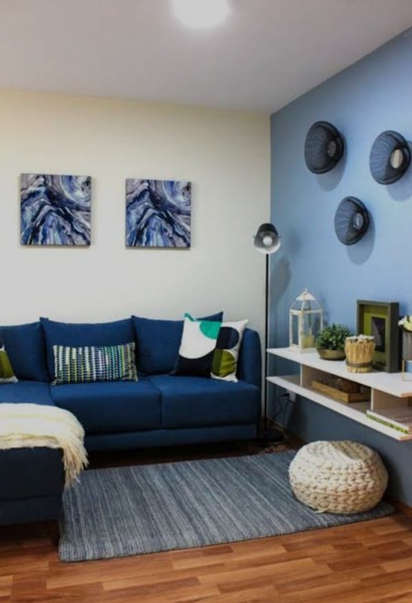 Interior de sala en departamento muestra general, CDMX. Sofá en tonos azules, decoración moderna