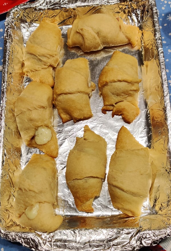 3 rows of 3 baked brie bites with cranberry orange jelly on a silver tray sitting on a winter table