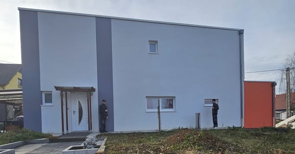 a man standing in front of a building with a man standing in front of it
