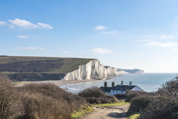 path leads to the coastguard cottages at Cuckmere haven with the Chalk cliffs of the seven sisters stretch into the distance