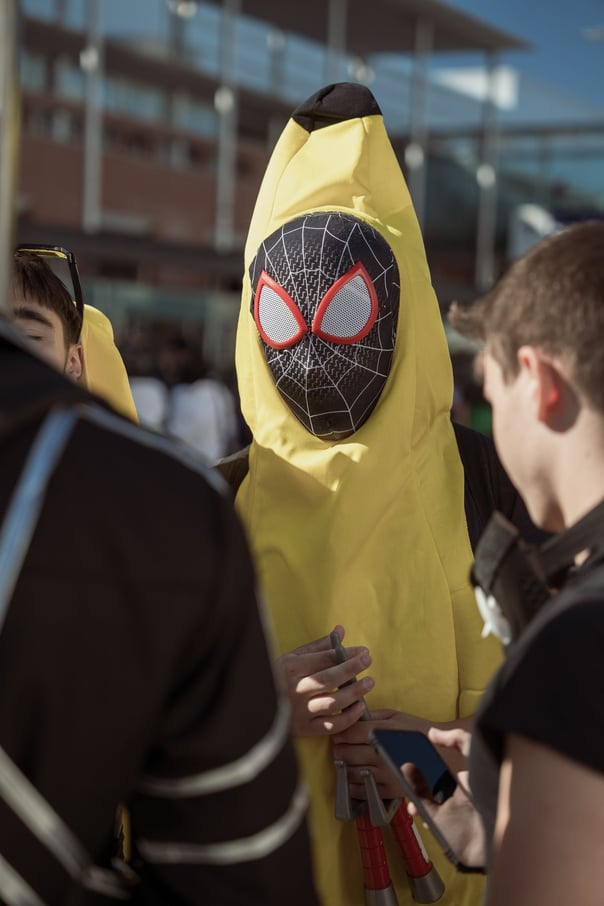 Person in a banana costume with a Spider-Man mask at Japan Weekend IFEMA. Surrounded by other attendees. Cosplay event