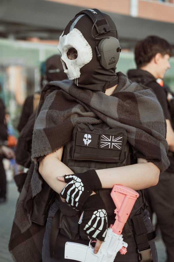 Cosplayer dressed as Ghost from Call of Duty at an event in Bilbao, Spain. Features skull mask, tactical vest, and UK flag pa