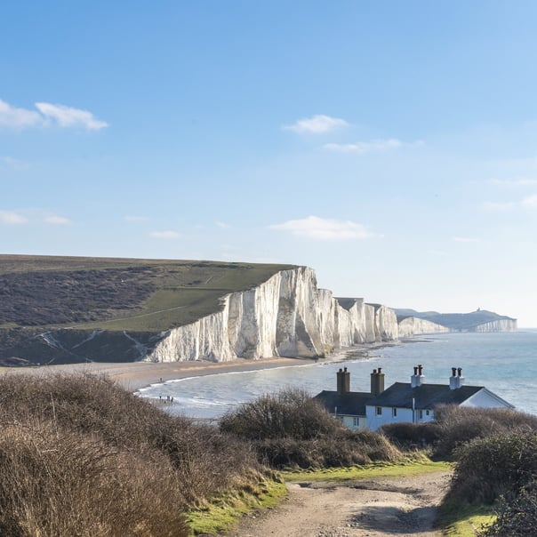 path leads to the coastguard cottages at Cuckmere haven with the Chalk cliffs of the seven sisters stretch into the distance