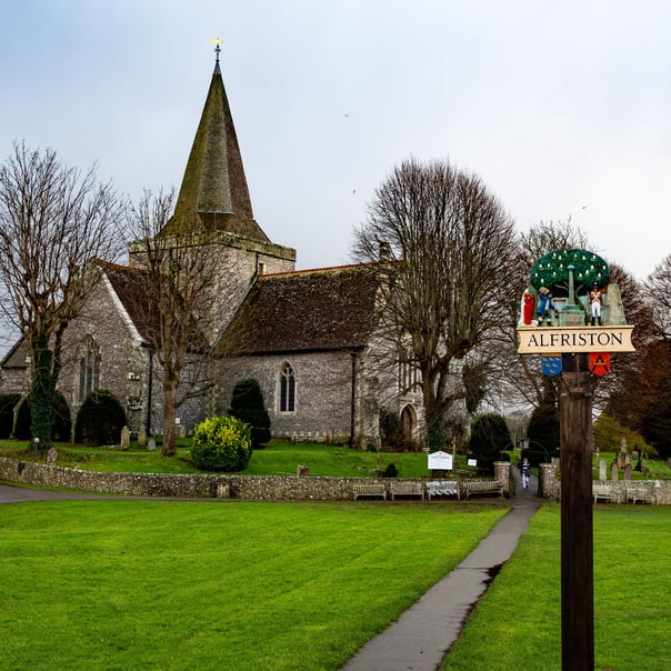 A photo of the Church of St Andrew in Alfriston surronded by leafless tress