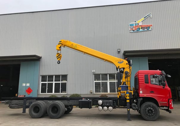 Yellow SQS300A-4 truck-mounted telescopic crane with robust boom, outdoors, ideal for heavy lifting.
