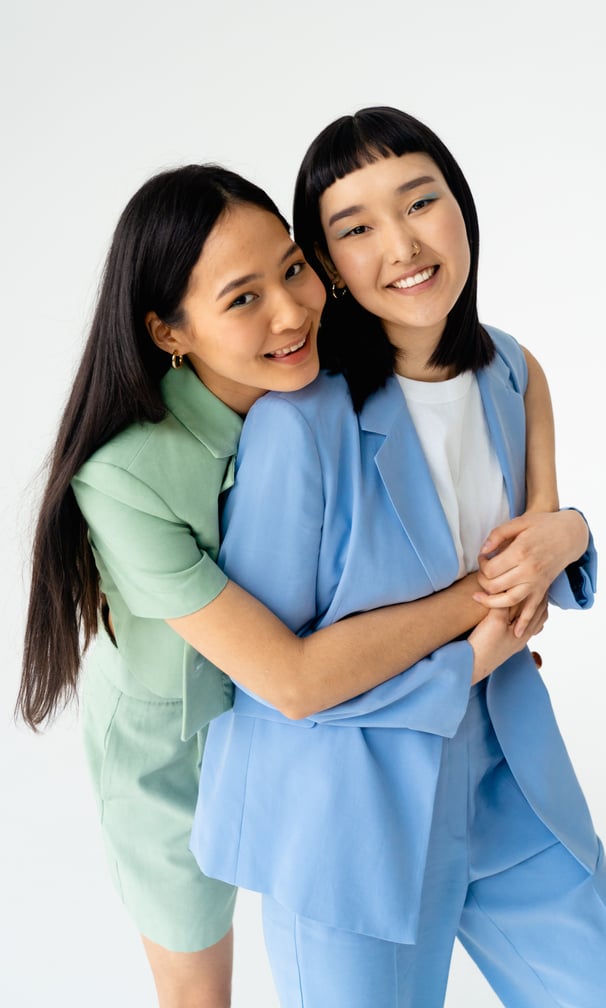 two women standing next to each other in a studio