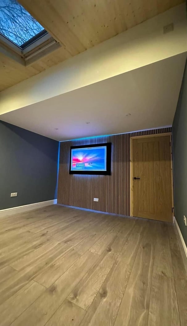 Garage conversion office- media wall with oak engineers floor and matt blue wall with white silk wo