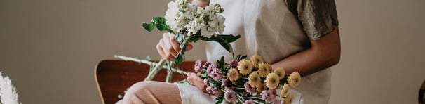 fotografía corporativa de una mujer con un delantal japonés de brie y un ramo de flores