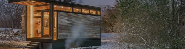 Modern prefab modular tiny home in a snowy forest setting