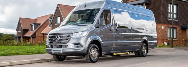 16 seater silver van parked on the side of a road