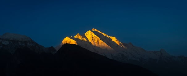 The sun lights up Rakaposhi at dawn. High resolution, gallery-quality prints.