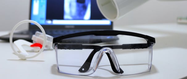 a laptop computer and a pair of X ray glasses on a desk
