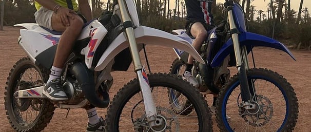 Moto cross 125 et 250 cc dans le désert marocain proche d'une palmerais