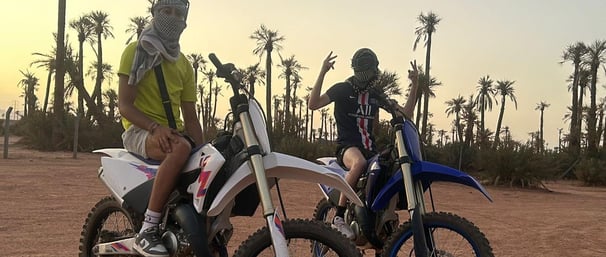 Moto cross 125 et 250 cc dans le désert marocain proche d'une palmerais