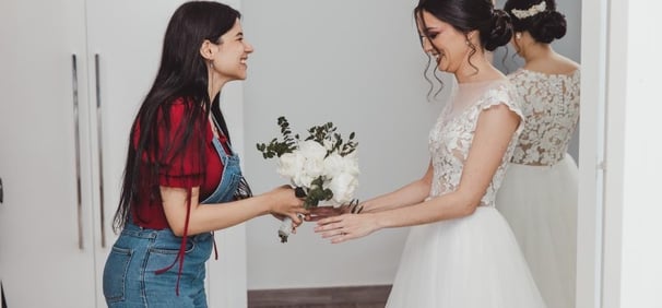 Una wedding planner entregando el ramo de flores a la novia