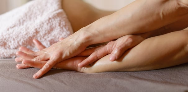 Gros plan sur des mains posées avec présence, symbolisant un toucher profond et bienveillant.