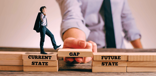 A businessman steps on blocks labeled "current state" and "Gap," held by a giant hand, moving toward "future state" blocks.