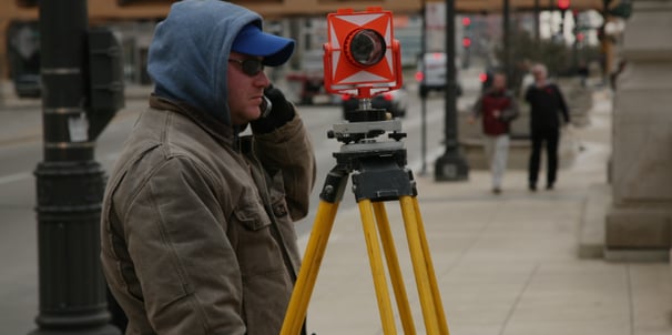 a man in a blue jacket and a camera on a tripod