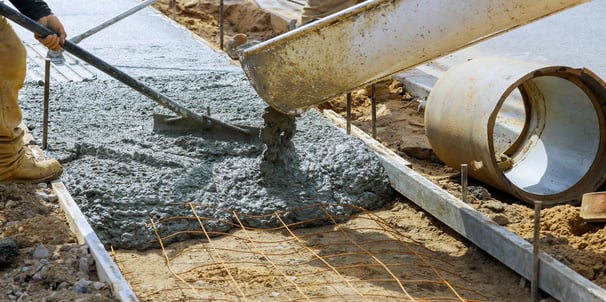 a man is pouring concrete into a concrete slab