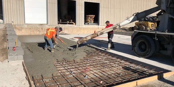 a man is pouring concrete into a concrete slab