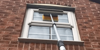 window being cleaned with an extension pole on house in malvern