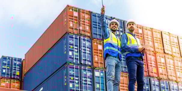 two men standing on a roof top of a building