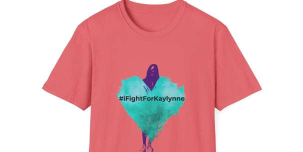 a coral colored graphic tee shirt with a teal heart and a shadow of a girl