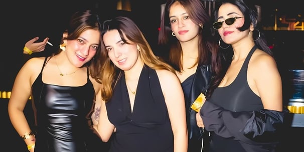 a group of women in black dresses standing in a row