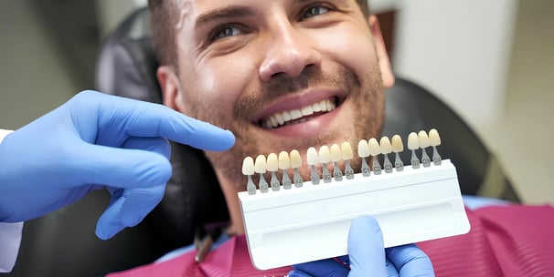 Paziente che sorride mentre si fa la prova colori per le faccette dentali