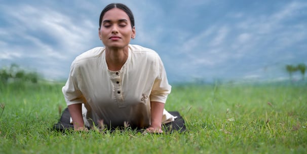 a woman doing Yoga on a grassy field